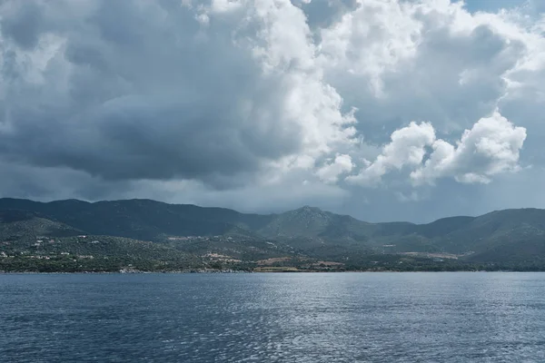 Panorama da paisagem marinha de um pequeno barco em um dia nublado ao longo da costa na sardenha . — Fotografia de Stock