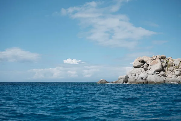 Vista del paisaje marino desde el barco con formación rocosa antropomórfica en un día soleado y cielo azul claro y nubes en Cerdeña . — Foto de Stock