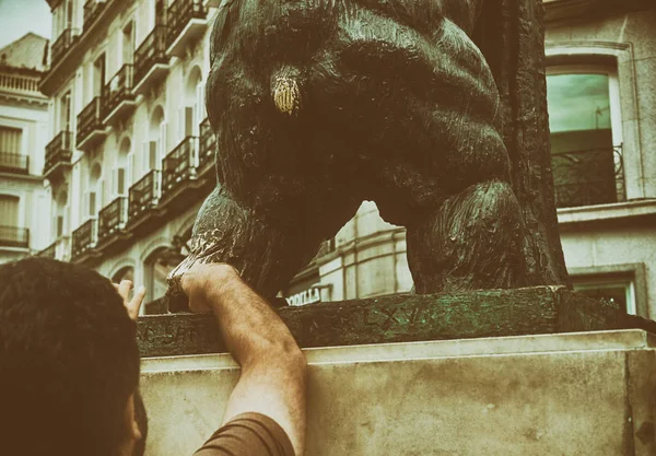 Mano de hombre tocando estatua de oso en Madrid España - gesto de superstición - Es una cosa que la gente hace para la buena suerte — Foto de Stock