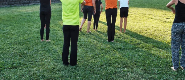 Народы, практикующие йогу в парке на закате . — стоковое фото