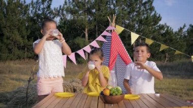 ormanda piknik, neşeli çocuklar wigwam yaz arka planda doğada dinlenirken öğle yemeği sırasında süt içme eğlenceli