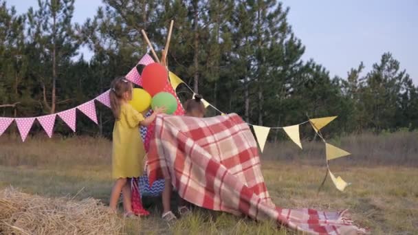 Små utomhus rekreation, glada barn dekorera gläntan med Lodge för rolig semester på picknick i skogen under sommar helgen — Stockvideo