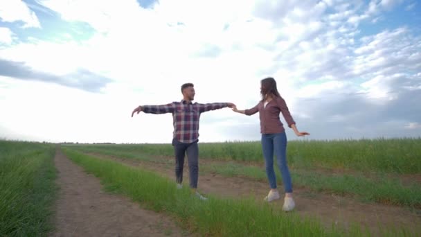 Casal apaixonado dançando em câmera lenta e desfrutar de fim de semana ao ar livre no campo no fundo do céu, relacionamentos felizes jovens — Vídeo de Stock