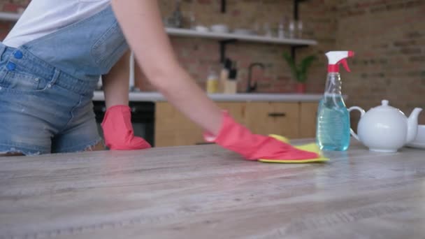 Limpieza de primavera, ama de casa con trapo y botella con medios para lavar con rociado frota mesa en la cocina — Vídeos de Stock