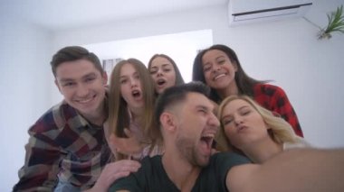 arkadaşlar ev partisinde akıllı telefon kullanarak selfie yapmak, genç kadın ve erkek kamera etrafında oyalama