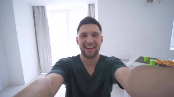 Lustige Gesichter, Junge mit Handy macht Selfie-Foto mit lustigen Freunden auf Heimparty — Stockvideo