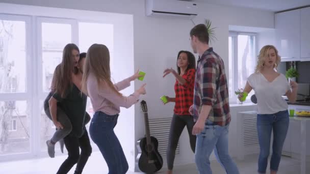 Gelukkige multinationale vrienden met plezier en dansen met plastic bekers in hun handen in prive-appartement op Home Party — Stockvideo