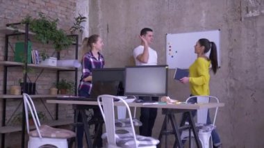 gün iş, güler yüzlü iş personeli birbirlerine yüksek beş veren masaya oturup bir not defteri ve tablet notlar yapmak