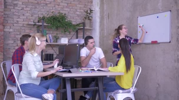 Desarrollo de negocios, gente de oficina en la mesa escuchando a un colega cerca de la pizarra y tomar notas en cuadernos — Vídeo de stock