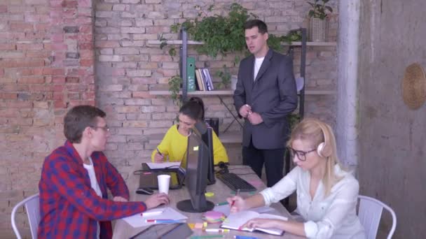 팀 리더 교육 연수생, 작업을 설명하고 현대 사무실에서 컴퓨터 화면을 가리키는 — 비디오
