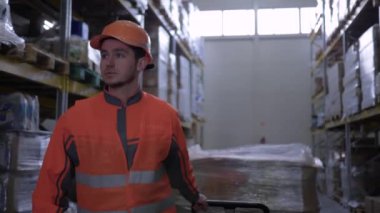 depoda raflar satır arasında kutular ile üniforma çekme arabası işçi