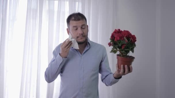 Alergie mężczyźni, mężczyzna z kwiatem w rękach cierpi na choroby układu oddechowego kichanie i chusteczki twarz ze względu na wrażliwość na pyłki — Wideo stockowe