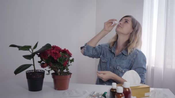 Maladie saisonnière, jeune belle femme à l'intérieur souffre et éternue d'allergies aux objets ménagers dans la chambre — Video