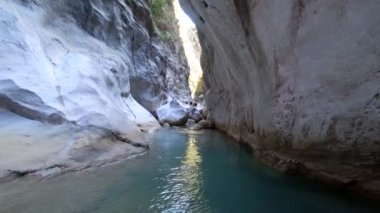 aşırı yerlere aktif gezi, koruyucu kask ve özel giysiler içinde turist grubu büyük taşlar ile deniz mağarası boğazına yaz tatili güneşli bir gün tadını çıkarın