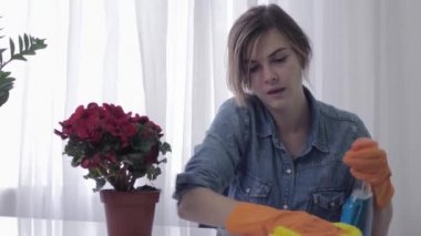 alerjik kız, yıkama spreyi ile genç kadın odasını temizler ve deterjan hapşırır