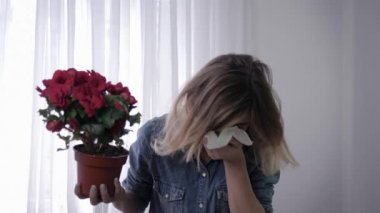 alerjik kız, polen duyarlılığı olan genç kadın elinde çiçek tutar ve sürekli mendil ile yüz silerek hapşırıyor
