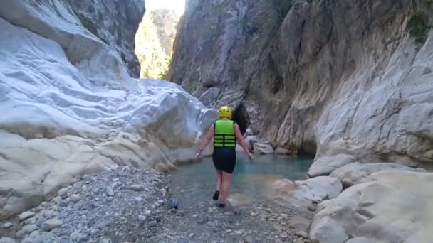 Excursão extrema, fins de semana de verão ativos de turista menina feliz em capacete protetor e roupas especiais caminhar através da caverna da montanha permite seguir-me na água — Vídeo de Stock