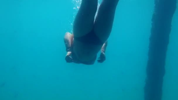 Vacances en mer, jeune fille sportive avec une belle plongée booty passe son week-end actif plongeant profondément dans l'eau et suivant les profondeurs et la beauté du fond marin et de la vie marine, tir sous-marin — Video