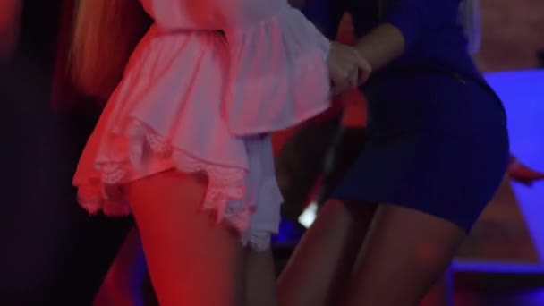 Kroppsrörelser, unga flickor med slanka figurer aktivt dansa åsnor på dansgolvet i nattklubb — Stockvideo