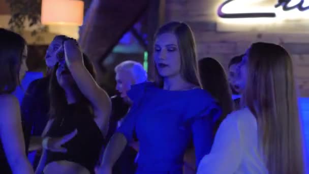 Танцы в ночном клубе, молодые женщины активно танцуют на танцполе дискотеки во время мальчишника — стоковое видео