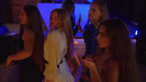 Dansen in een nachtclub, sexy actieve vrouwtjes met lang haar plezier bewegen op de vloer tijdens een feestje — Stockvideo