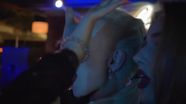 Vriendinnen in nachtclub, portret van jonge glamoureuze meisjes in een omhelzing dansen op een cool feestje in lichte muziek — Stockvideo