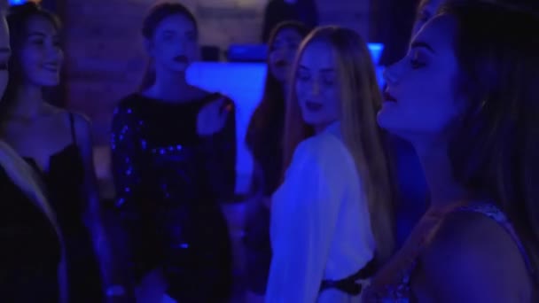 Fiesta de novias, mujeres jóvenes glamorosas se mueven juguetonamente en la pista de baile de discoteca con sus amigos — Vídeo de stock