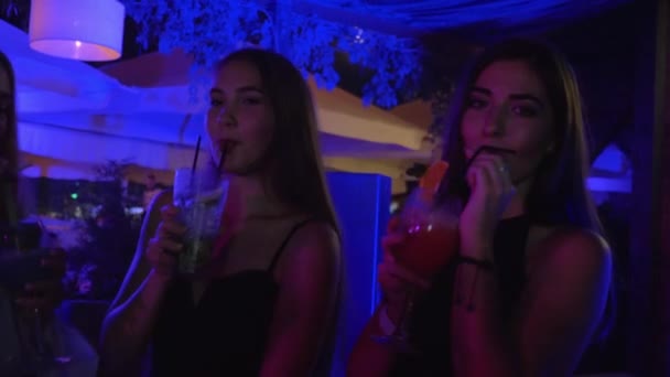 Mooie jonge vrouwen met plezier op vrijgezellenfeest in een nachtclub met exotische dranken op de dansvloer — Stockvideo