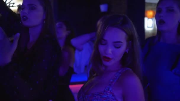 junges sexy Mädchen tanzt auf der Tanzfläche mit ihren Freundinnen in einem Nachtclub während eines Junggesellenabschieds