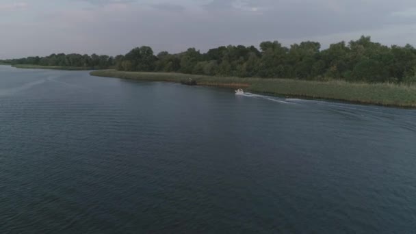Aerial view on sports person rides on board behind motorboat along river at open air in summer evening — Stock Video