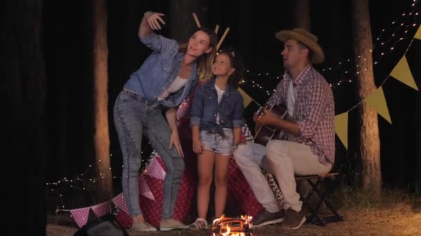 Rust op de picknick, moeder neemt foto met haar geliefde man en dochter tijdens de nacht reis naar het bos op zomervakantie — Stockvideo