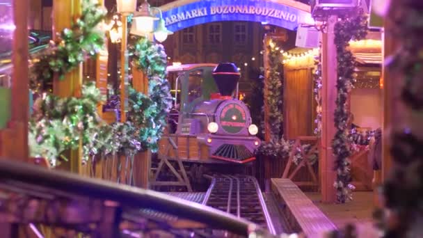 Attrakciója a vonat kocsik lovagol a sínek a turisták a téli ünnepek alatt a karácsonyi vásár — Stock videók
