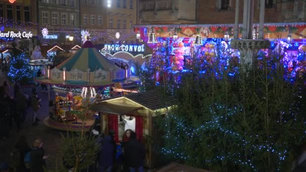 Рождество в Европе, туристы прогуливаются на рождественском рынке ночью мимо освещенных киосков — стоковое видео