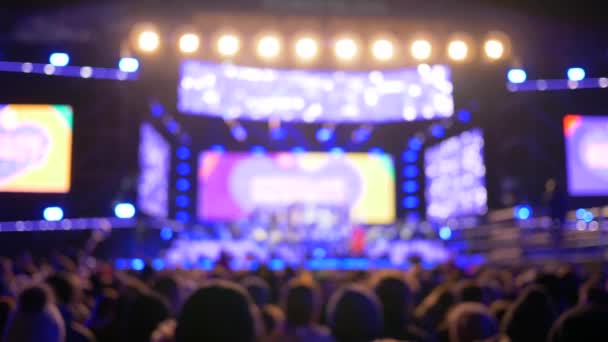 Blurred glare from spotlights at concert with crowd people in the evening — Stock Video