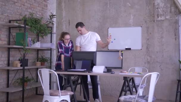 Dagelijks werk in kantoor, medewerkers die elkaar hoog vijf geven en aan tafel gaan zitten met computer en laptops — Stockvideo
