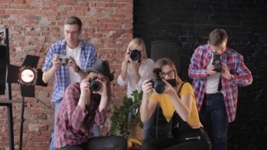 masterclass birçok fotoğrafçı kamera fotoğraf çekmek sonra ellerini kaldırın ve stüdyoda bir tuğla duvarın arka planda gülümseme