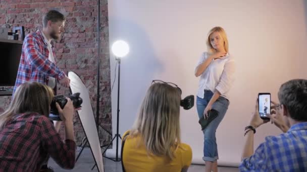 Παρασκηνιακά γυρίσματα, ομάδα κάμεραμαν με κάμερες Slr και βοηθοί διεξάγει επαγγελματική φωτογράφηση του όμορφου μοντέλου κατά τη διάρκεια του σεμιναρίου — Αρχείο Βίντεο