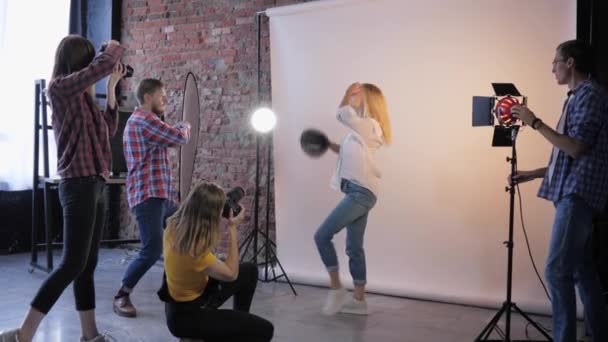 Travail créatif, jeunes spécialistes avec appareils photo numériques travaillant avec beau modèle en studio photo à l'atelier de photographe — Video
