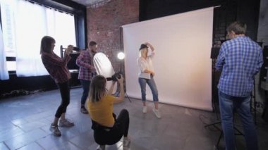 Fotoğraf atölyesi, yaratıcı fotoğrafçılardan oluşan bir şirket stüdyo çekimlerinde genç modelin fotoğraflarını çekiyor.