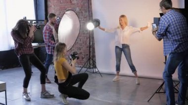 Slr kameralı moda profesyonelleri fotoğraf stüdyosunda mankenlerle fotoğraf çekiyorlar.