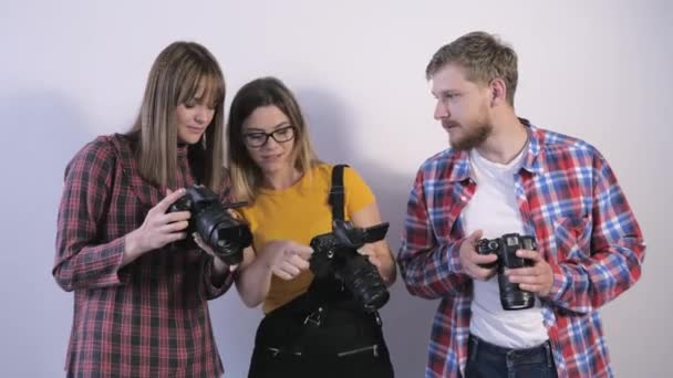 Fotógrafos estudar configurações de câmera, profissionais com câmeras explorar especificações técnicas durante oficina na escola de fotografia — Vídeo de Stock