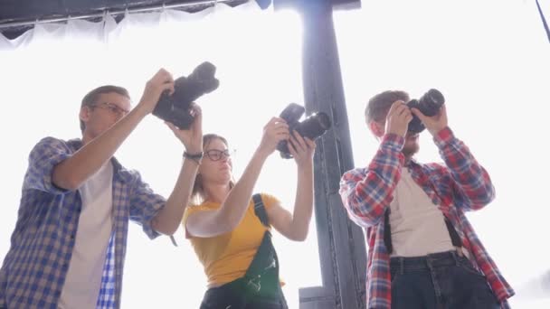 Хобби фотографии, молодые специалисты делают снимки на SLR камеры в фотостудии во время семинара для фотографов — стоковое видео
