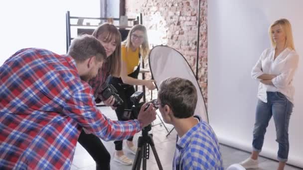 Εργαστήριο φωτογραφίας, ομάδα φωτογράφων συζητούν τις ρυθμίσεις της ψηφιακής φωτογραφικής μηχανής κατά τη διάρκεια επαγγελματικού εργαστηρίου φωτογραφίας — Αρχείο Βίντεο