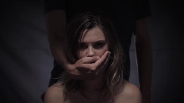 Problema sociale della violenza domestica, vittima femminile indifesa soffre di abusi da parte del marito che chiude la bocca con la mano e la afferra grossolanamente — Video Stock