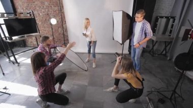 Moda atölyesinde modern fotoğraf stüdyosu için fotoğraf çekimi sırasında profesyonel modeller kameraya poz veriyor.