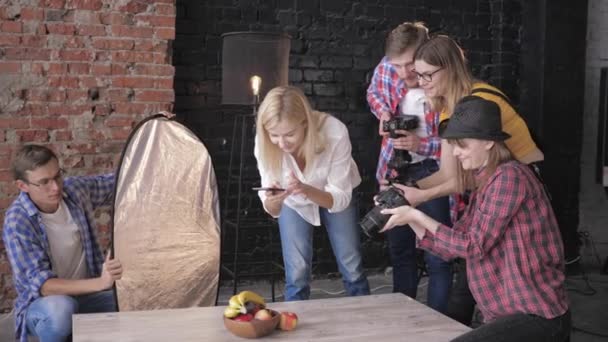 Food-Fotografie: Junge Kreative mit Slr-Kameras in der Hand fotografieren Früchte während der Ausbildung für Fotografen