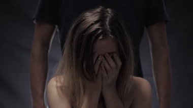 kadına saldırganlık ve şiddet, lekeli maskara ile ağlayan kız karanlık odada yumrukları ile kaba kocasının arka planda gözyaşlarını siler