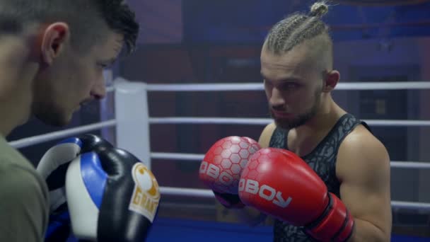 Match de boxe, les lutteurs gars se battent avec les poings dans des gants de boxe tout en combattant sur le ring lors de compétitions close-up, slow motion — Video