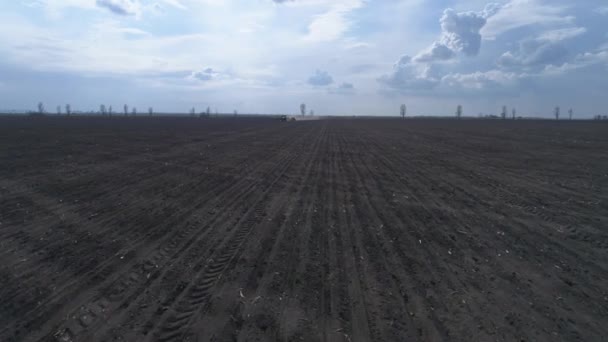 Vue de drone sur le sol brun labouré et beau ciel, machines agricoles sur le champ de labour — Video