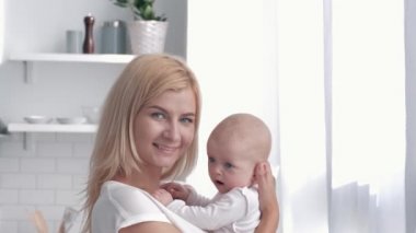 evde mutlu aile portresi, yeni anne sarılma ve mutfakta yeni doğan kız öper